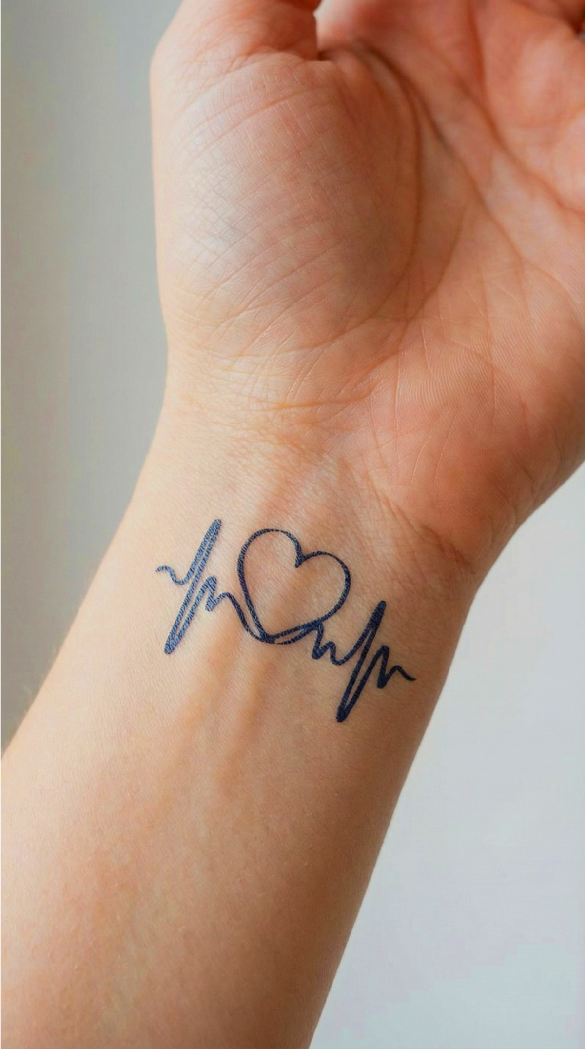 Tatuaj cu un model simplu, cu linii curate, în formă de inimă, ca reper pentru dimensiune și grosimea liniilor